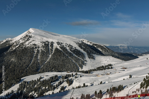 Dolomites, ski area with beautiful slopes. Empty ski slope in winter on a sunny day. Prepared piste and sunny day