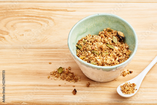 Homemade granola in a bowl on a wooden table.