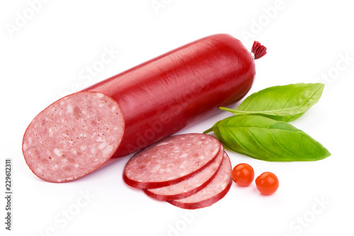 Italian smoked Salami sausage with slices and basil leaves, close-up, isolated on a white background