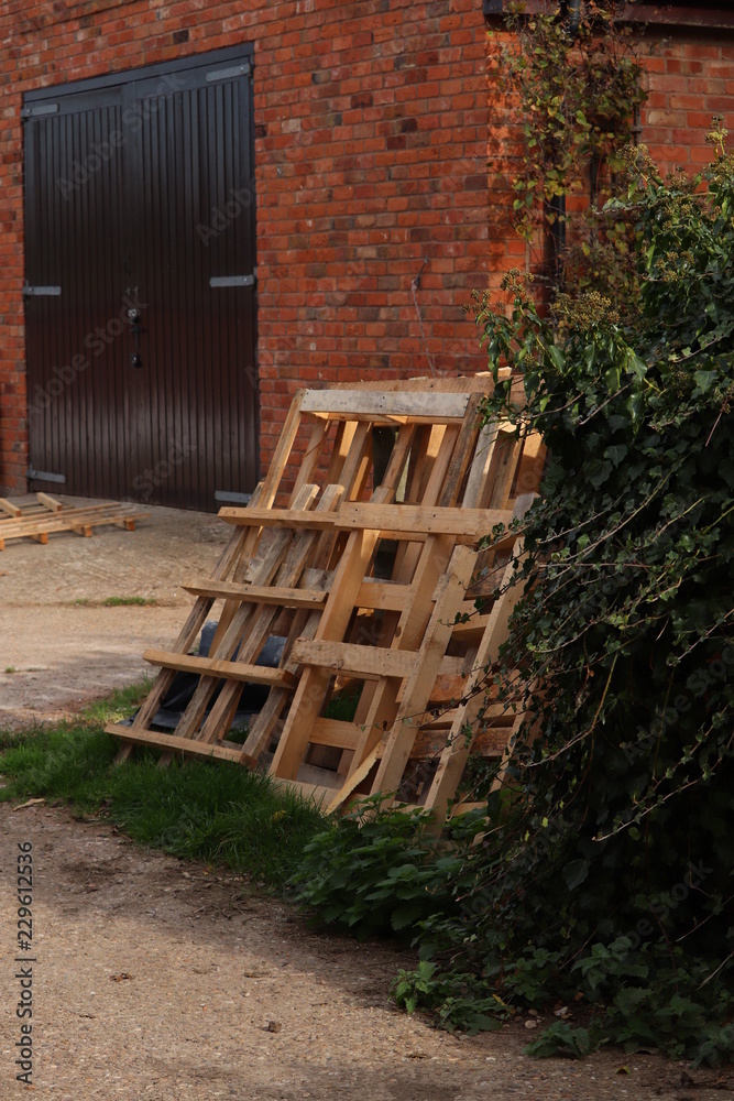 wooden pallets leaning against a brick wall wooden pallets leaning against a brick wall