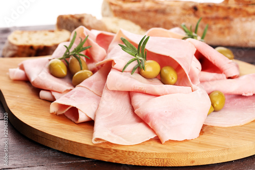 Sliced ham on wooden background. Fresh prosciutto. Pork ham sliced.