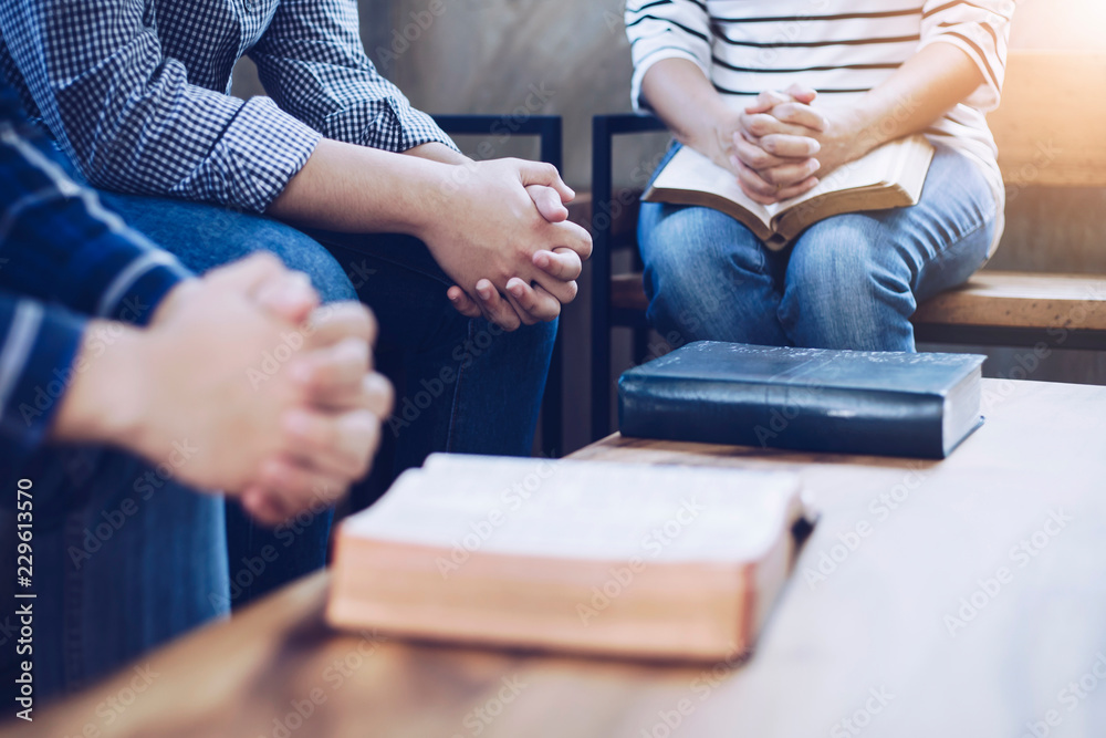 Obraz premium Christian group are praying together around wooden table with holy bible