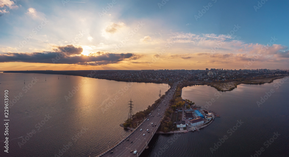 Aerial view of Vograsovsky bridge with car traffic connecting Left Bank and Leninsky districts of Voronezh, panoramic view at sunset