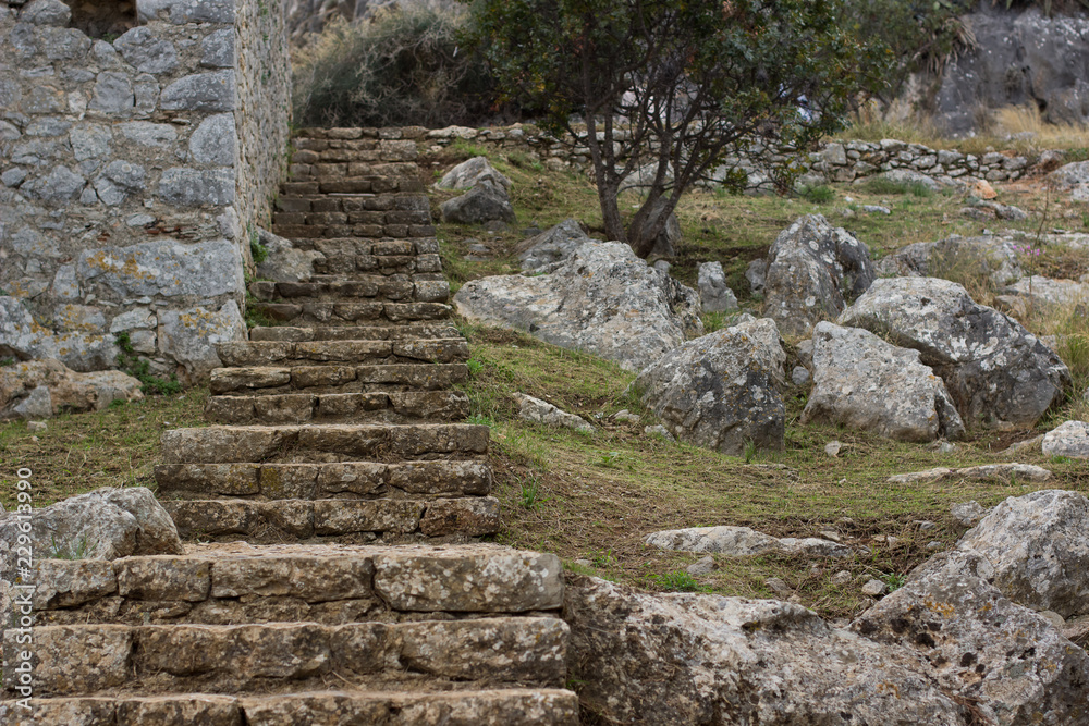 small narrow stone stairs in ancient ruins of old castle