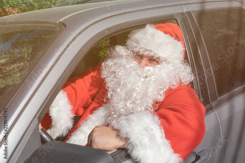 A man dressed as Santa Claus delivers gifts on the car. Stress and road problems