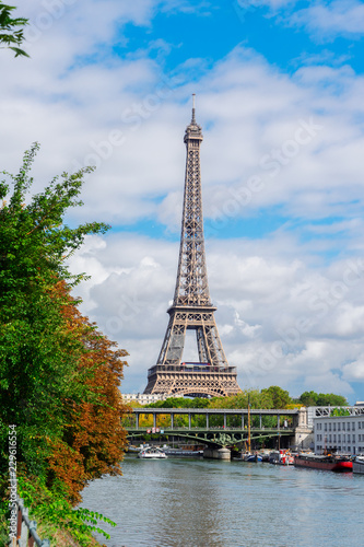 famous Eiffel Tour over Seine river with green trees, Paris, France