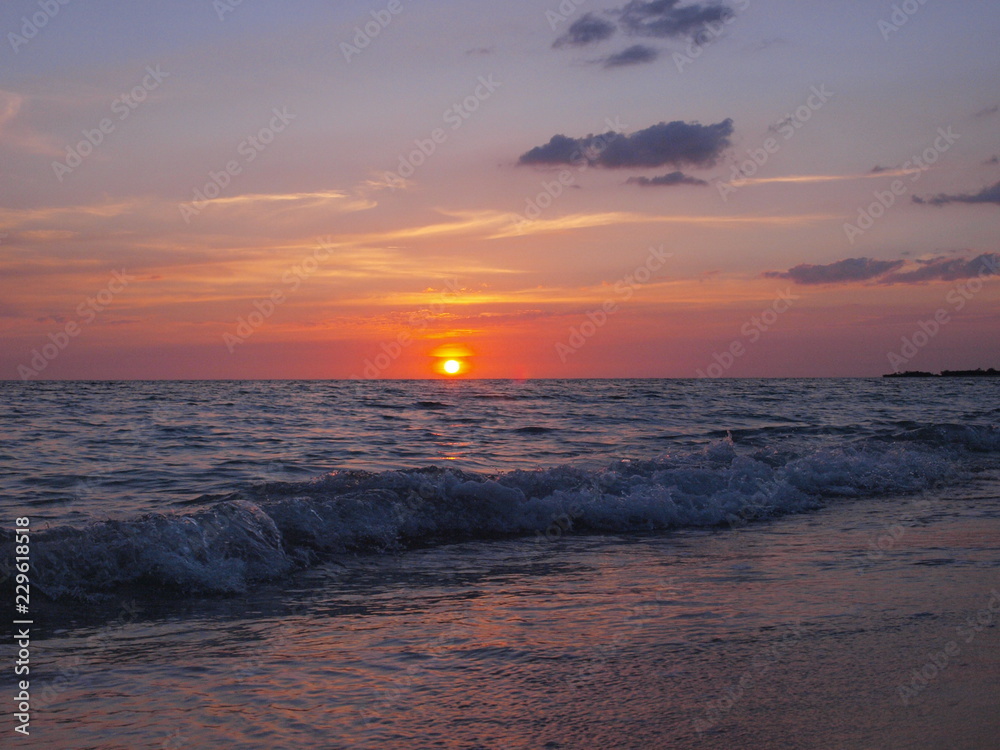 Obraz premium Playa Ancón, Espíritu Santo, Cuba - June 28, 2018: Spectacular sunset on the Ancon beach with all pink, purple and blue
