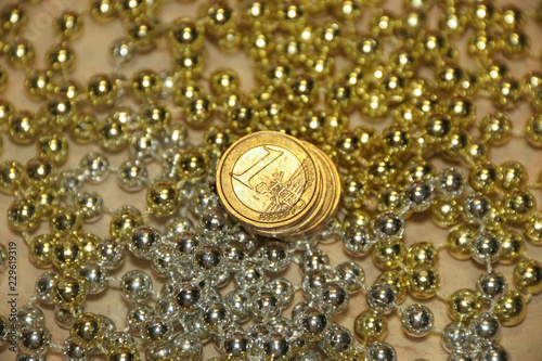 Stack of euro coins in light golden and silver metal glitter beads on marble background abstract vintage texture
