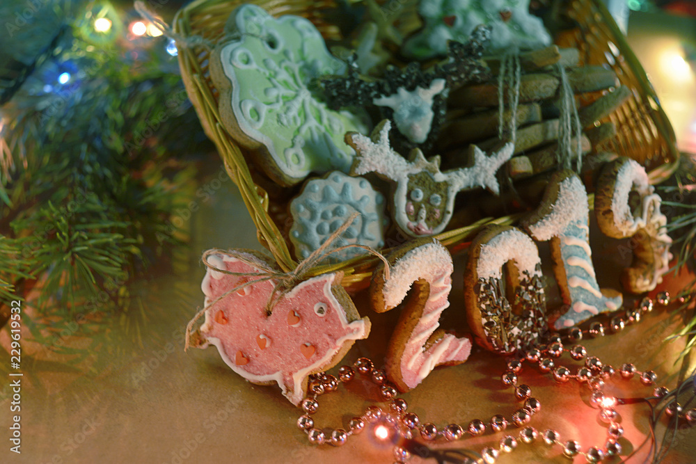 Christmas or New Year, still life with a painted gingerbread in a basket in the form of a pink pig and tsifer 2019, surrounded by beads and garlands. Close-up.