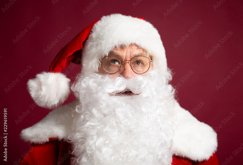 Santa Clause in eyeglasses looking up on red background, Christmas and New year concept