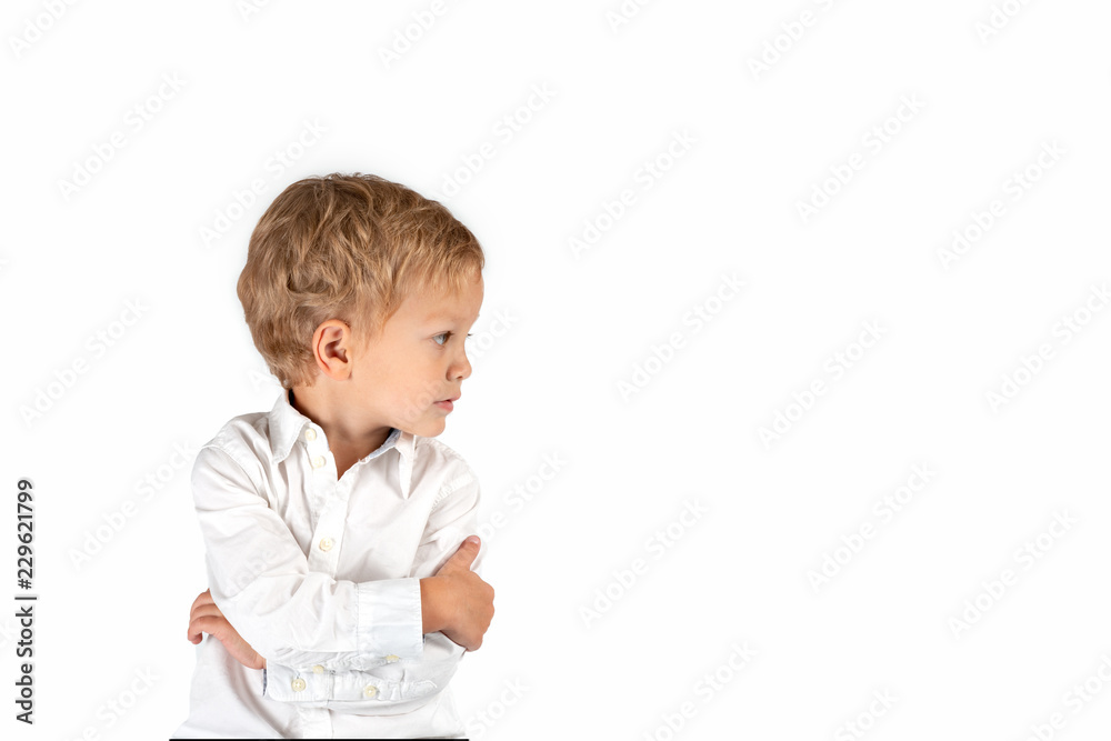 Waist up portrait of a little serious boy wearing white shirt. He purposefully looks away, on a white background in the studio Waist up portrait of a little serious boy wearing white shirt. He purposefully looks away, on a white background in the studio