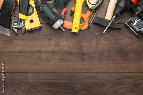 different construction tools on wooden background with copy space. diy construction tools on the brown table