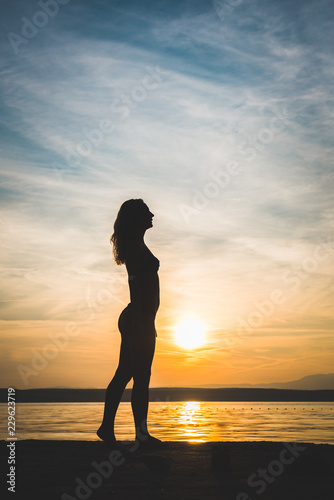 Young attractive girl model silhouette on the beach photo