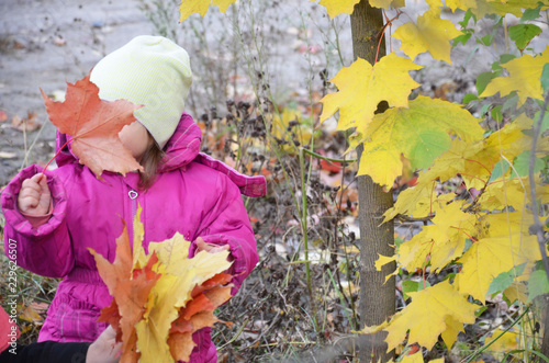 Happy little child. Child walking in warm jacket outdoor. Girl happy in pink coat enjoy fall nature park. Child wear fashionable coat with hood. Fall clothes and fashion concept. photo