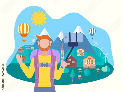 A man takes a selfie on the background of a mountain village, balloons and landscape.