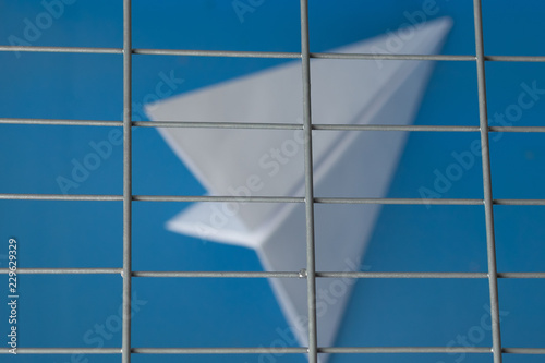 Russia is blocking Telegram: silhouette of a paper plane behind bars on a blue background photo