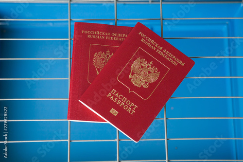 The Concept Of Russian Sanctions. Passport on the grid on a blue background photo