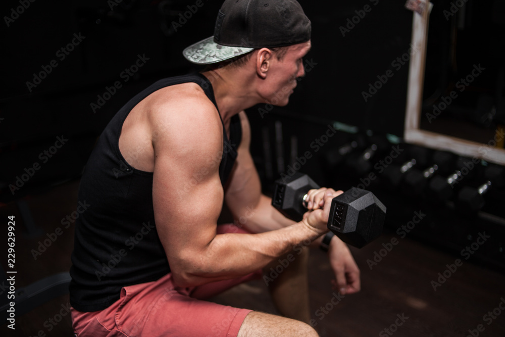 man at the gym doing exercise with dumbbells for biceps man at the gym doing exercise with dumbbells for biceps