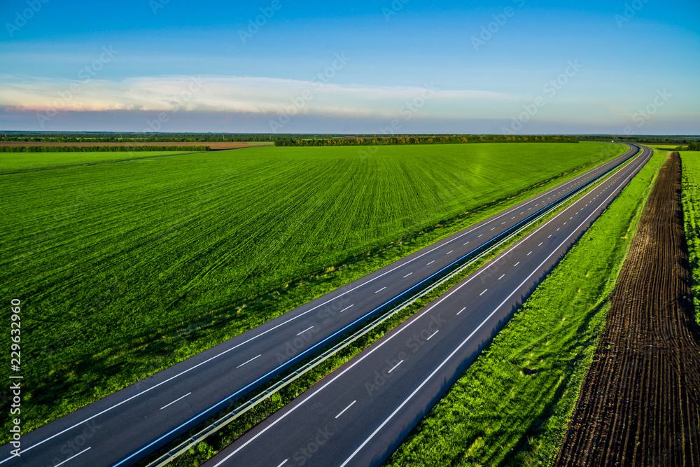empty asphalt road along the green fields. Road seen from the air. Aerial view landscape. drone photography. highway
