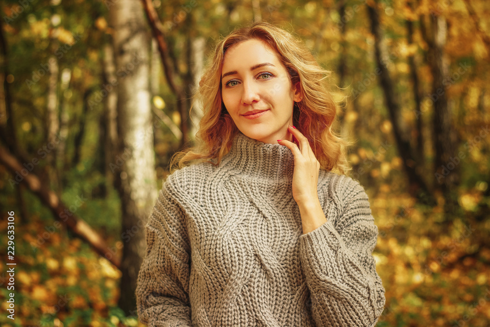 Young beautiful girl in a knitted sweater on the background of autumn park with fallen leaves Young beautiful girl in a knitted sweater on the background of autumn park with fallen leaves
