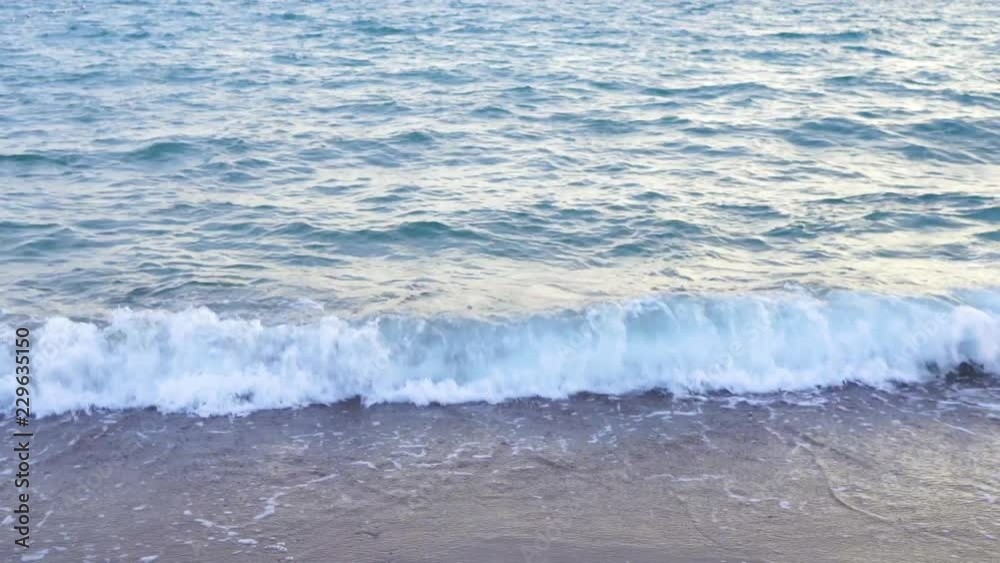 Blue surface of splashing sea water at sandy beach during sunset time. Beautiful nature background. Turkey. Real time 4k video footage. Blue surface of splashing sea water at sandy beach during sunset time. Beautiful nature background. Turkey. Real time 4k video footage.