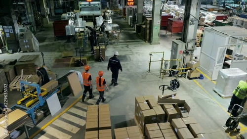 A group of workers in overalls goes inside the shop