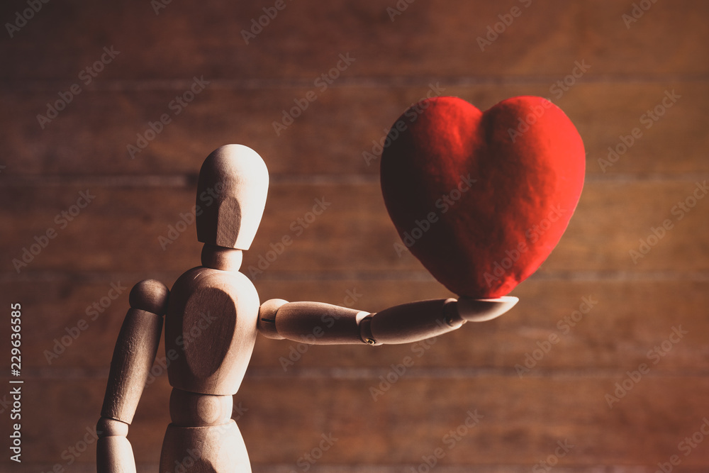 photo of the beautiful gestalta with heart-shaped toy on the brown wooden background photo of the beautiful gestalta with heart-shaped toy on the brown wooden background