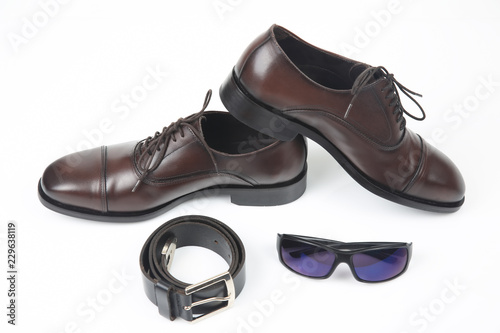 Classic men's shoes, belt and glasses on white background