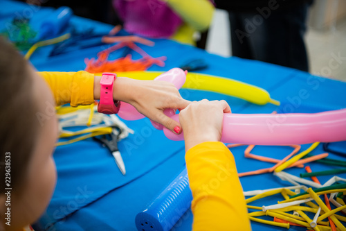 Fotografie Happy children girl's hands with balloon on twisting art workshop