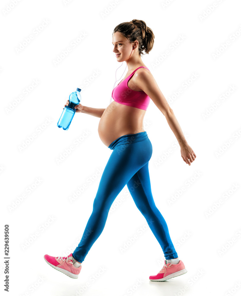 Sporty pregnant woman in sportswear jogging on white background. Dynamic movement. Concept of healthy life Sporty pregnant woman in sportswear jogging on white background. Dynamic movement. Concept of healthy life