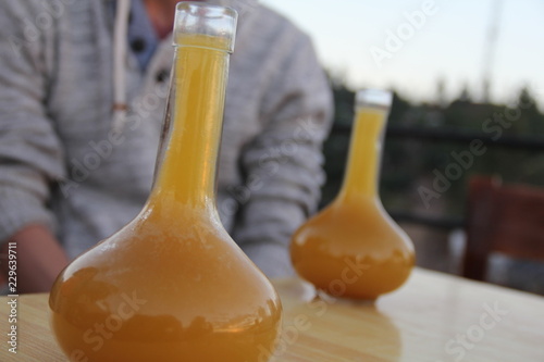 Carta da parati Two glasses of Ethiopian tej, a mead or honey wine, in a rounded vase-shaped container called a berele, which looks like a Florence flask