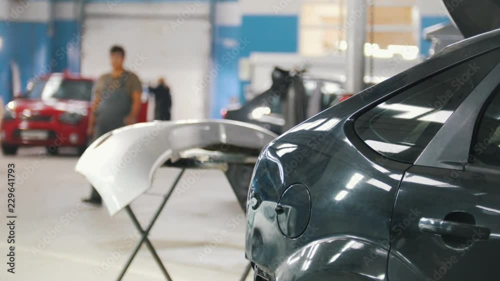 Car repair service. Bumper and rear of the machine in focus. Walking people in the backgrond Car repair service. Bumper and rear of the machine in focus. Walking people in the backgrond