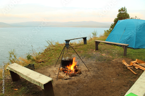 Fototapeta Naklejka Na Ścianę i Meble -  Tent and bowler on the lake. Background. Landscape.