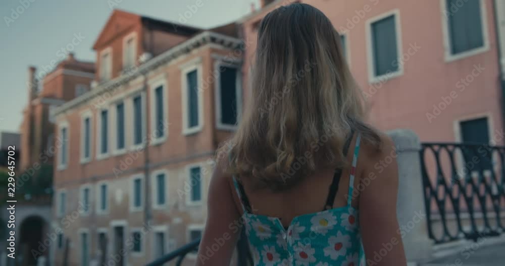Young woman crossing a bridge in Venice at sunrise Young woman crossing a bridge in Venice at sunrise