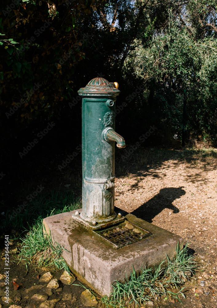 Water column in the street with concrete base and flowing water Water column in the street with concrete base and flowing water