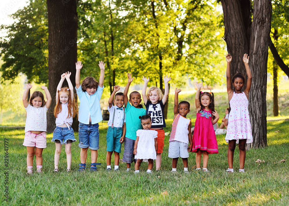 A large group of preschool children playing in the Park on the grass. The concept of friendship, childhood.Children's day, June 1 A large group of preschool children playing in the Park on the grass. The concept of friendship, childhood.Children's day, June 1