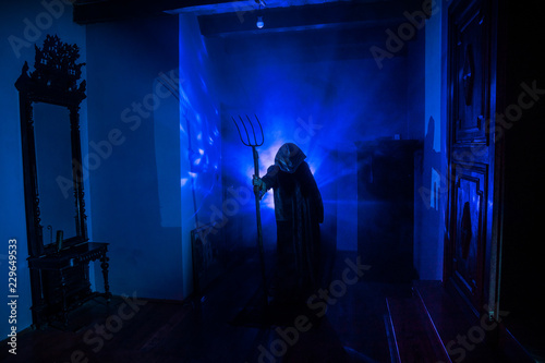 Horror silhouette of ghost inside dark room with mirror Scary halloween concept Silhouette of witch inside haunted house with fog and light on background.