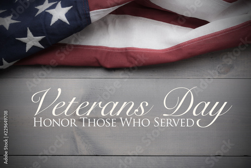 The flag of the United Sates of America on a grey plank background with Veterans Day greeting