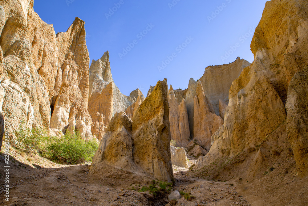 Fototapeta premium Inside the valley looking at the surrounding tall clay cliffs at Omarama in New Zealand