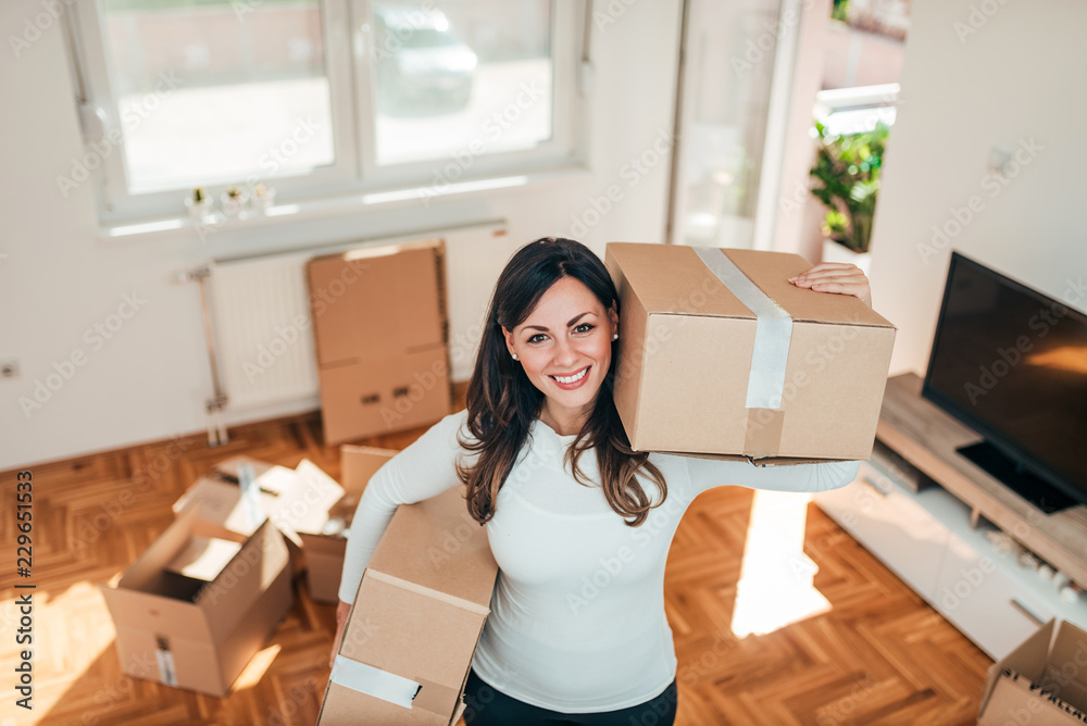 Lovely smiling woman moving with boxes at new apartment and looking at camera. Lovely smiling woman moving with boxes at new apartment and looking at camera.
