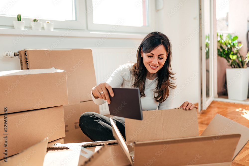 Lovely brunette unpacking at her new apartment. Lovely brunette unpacking at her new apartment.