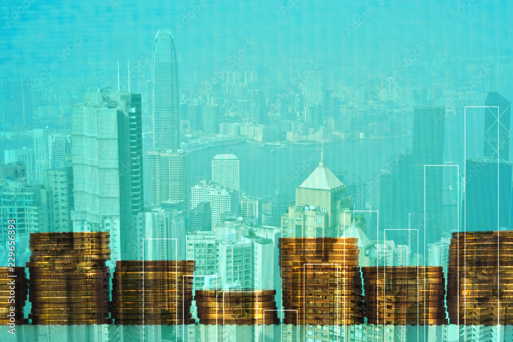 Double exposure Stack of coin with financial graph over city and office building background, business and financial concept.