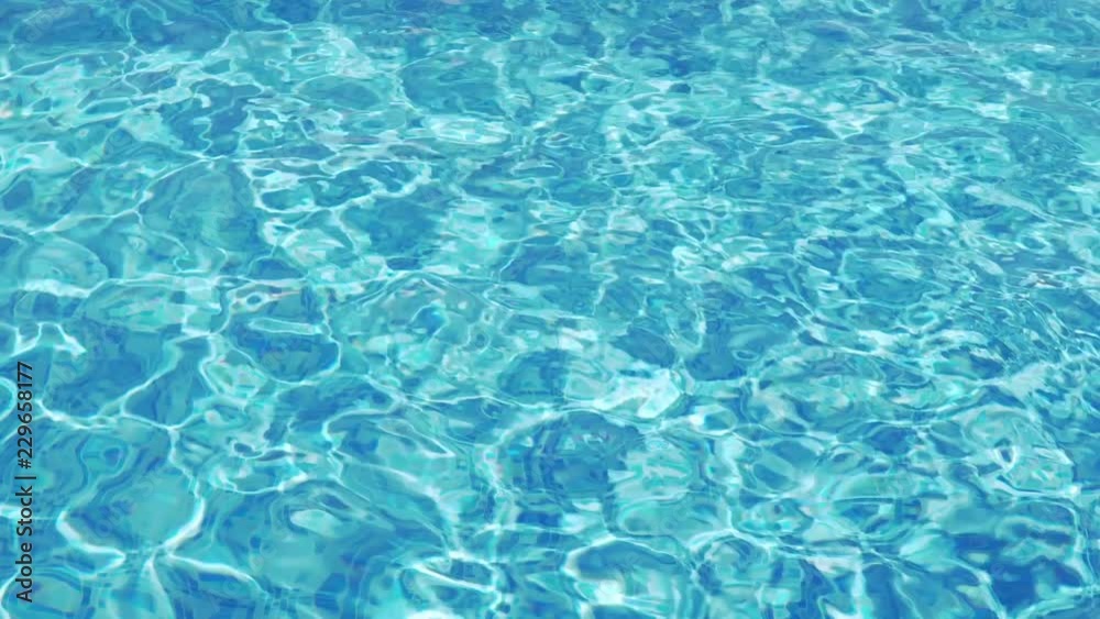 Calm rest on a sunny day. Background of a pool with wavy clean fresh water at sunset of the day. Reflection of clear blue pool water, flashes. Texture bright turquoise surface of the water in the pool Calm rest on a sunny day. Background of a pool with wavy clean fresh water at sunset of the day. Reflection of clear blue pool water, flashes. Texture bright turquoise surface of the water in the pool