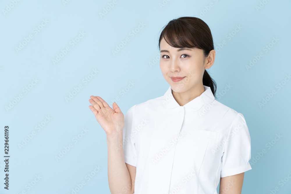 portrait of young asian nurse on blue background portrait of young asian nurse on blue background