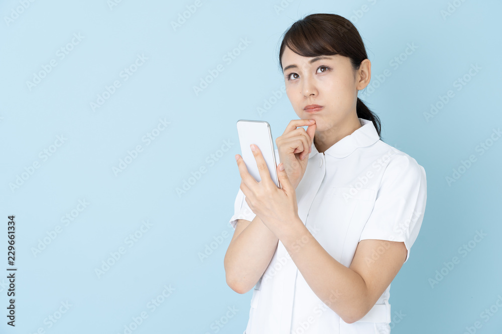 portrait of young asian nurse on blue background portrait of young asian nurse on blue background