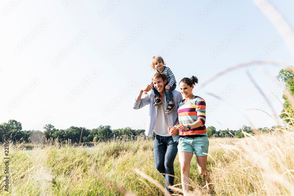 Happy family walking at the riverside on a beautiful summer day