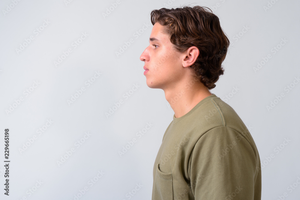 Young handsome man with wavy hair against white background