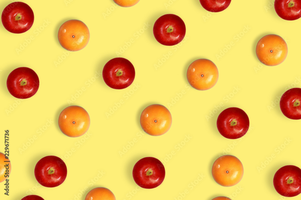 orange and apple pattern on yellow pastel background orange and apple pattern on yellow pastel background