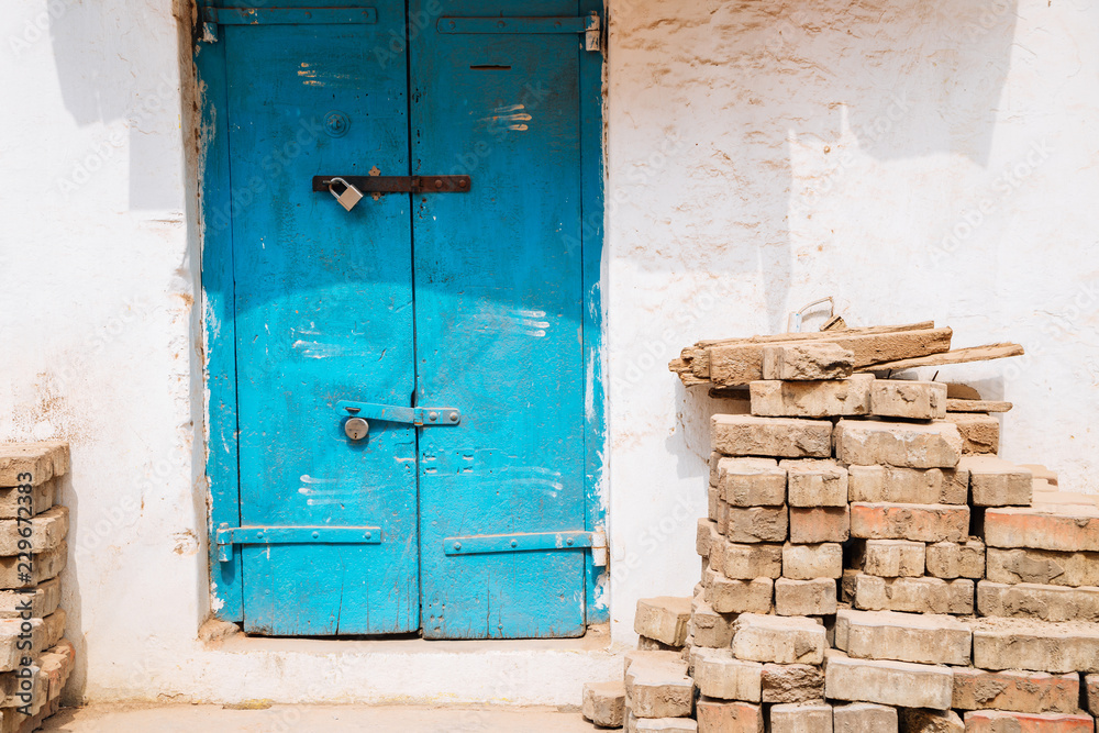 Old house exterior, Blue door and stacked bricks in Madurai, India