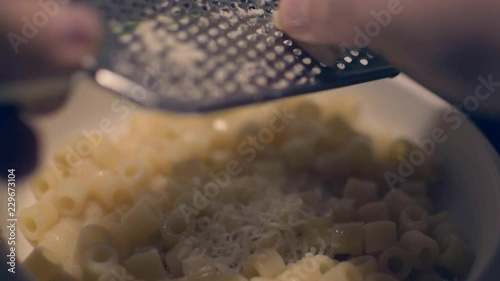Grattuggiare formaggio sulla pasta. Grating cheese on pasta photo